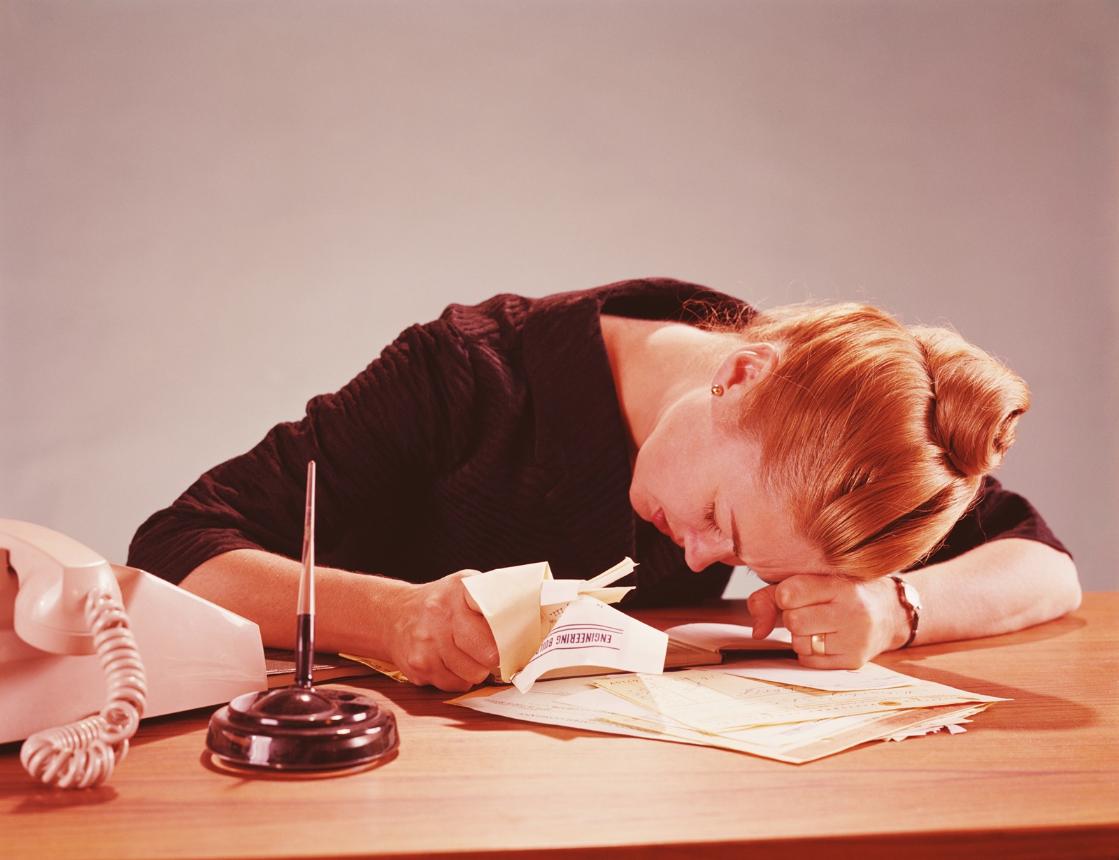 Woman frustrated at a desk in need of a technical writing workshop