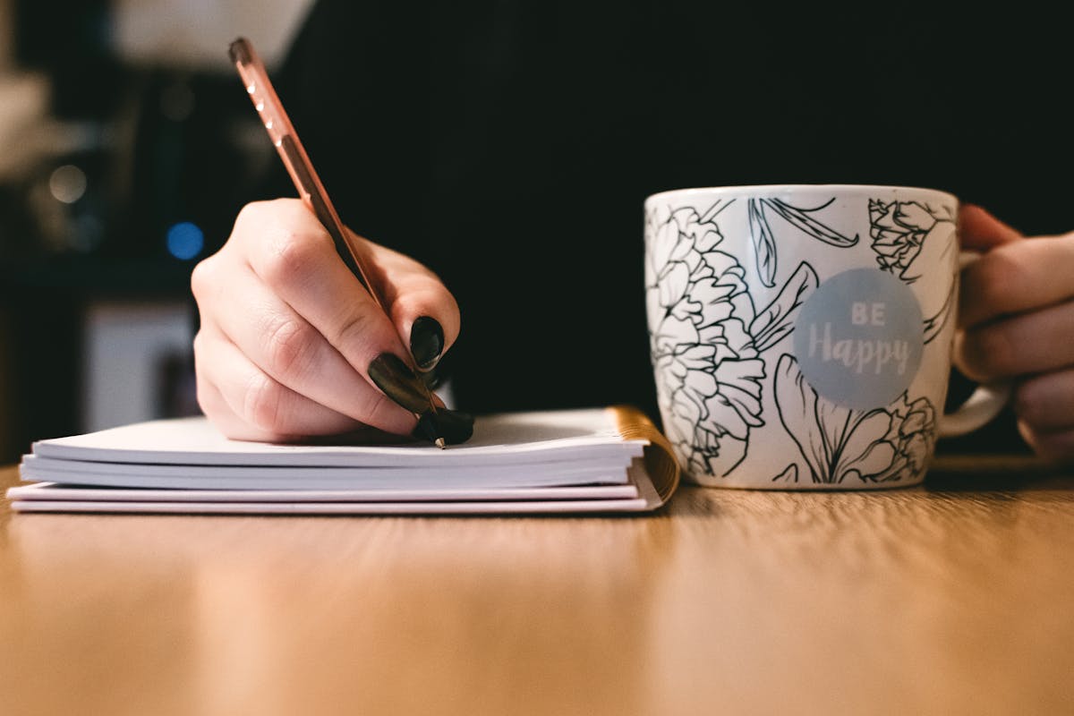 A person writing down something on a notebook