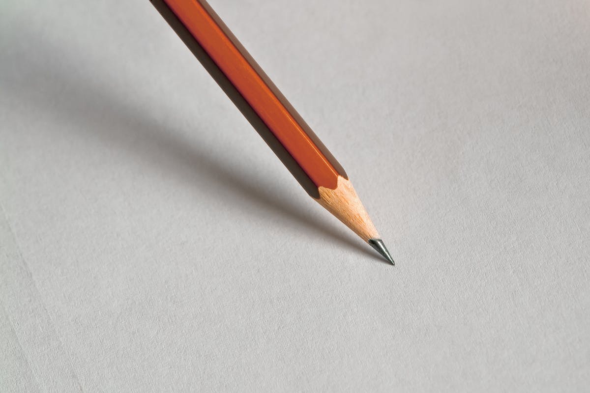 A pencil sitting on top of a piece of paper