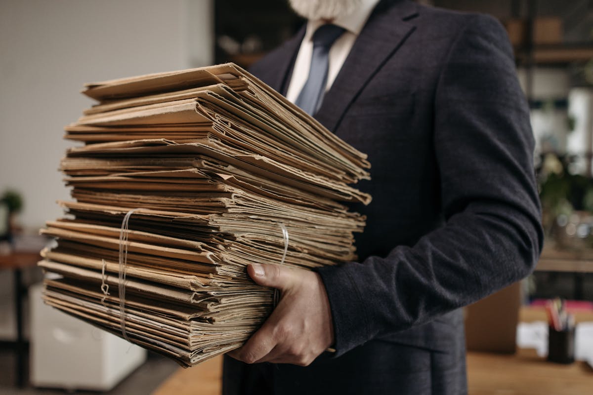 A man holding a bunch of old documents